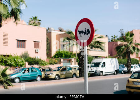 Signe de la circulation de l'avertissement et les charretiers dans une rue animée de Marrakech. Bloqué dans la circulation des voitures dans l'arrière-plan Banque D'Images