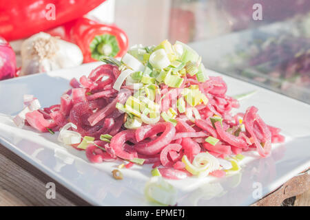 Tranche d'oignons rouges marinés, décorées avec des poireaux. En face de légumes Banque D'Images