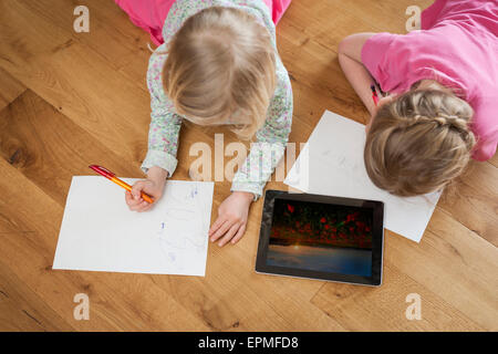 Deux soeurs avec tablette numérique et de feuilles de papier sur marbre Banque D'Images