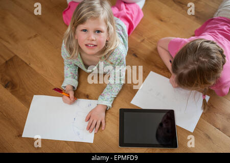 Deux soeurs avec tablette numérique et de feuilles de papier sur marbre Banque D'Images