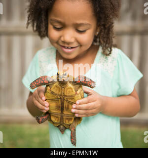 Un enfant tenant une tortue. Banque D'Images