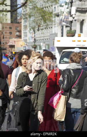 Les jeunes à pied le long de la foule du trottoir sur la 14e rue a adopté l'Union Square à Manhattan, New York. Banque D'Images