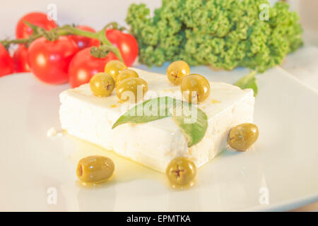 Feta et olives vertes, en face de tomates et de chou vert Banque D'Images