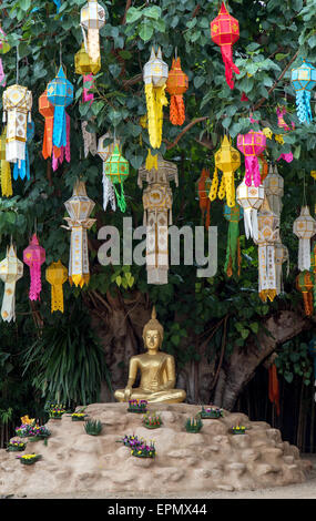 Lanternes chinoises accrocher sur l'arbre sous lequel Bouddha assis Banque D'Images