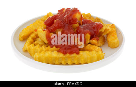 Frites croustillantes couverts avec du ketchup dans une petite assiette, isolé sur un fond blanc. Banque D'Images