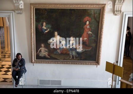 Gardien de sécurité assis à côté d'une peinture du 17ème siècle au château de Versailles, France. Banque D'Images