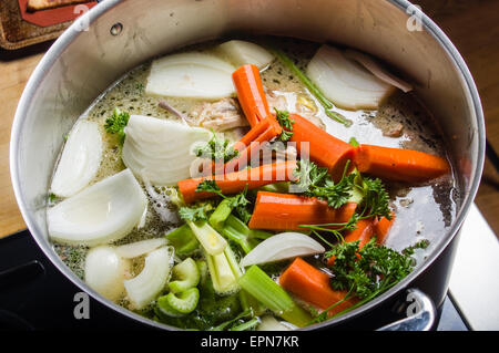 Une grande marmite sur la cuisinière avec des légumes coupés pour faire de la soupe Banque D'Images
