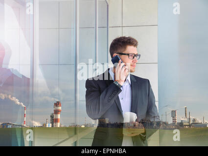 Double Exposure of urban attractive businessman avec périphérique de téléphonie et de l'industrie du bâtiment historique de l'entreprise Banque D'Images