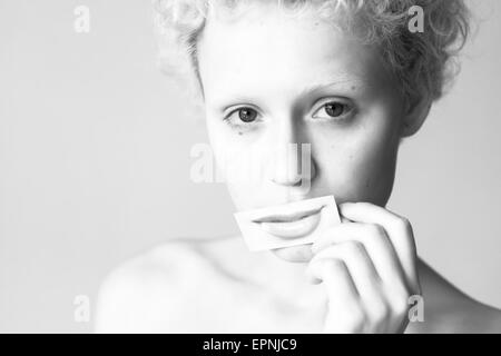 Tendre jeune fille se ferme ses lèvres à lèvres peint photo. La photographie noir et blanc et des couleurs vives. Banque D'Images