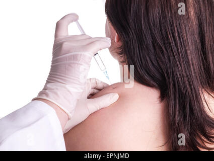 Jeune femme est à l'injection dans la partie supérieure du manche de l'épaule . Elle a une raideur du cou et obtient un blocus. Isolé sur blanc. La photo Banque D'Images