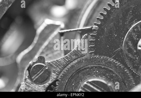 Black metal fond blanc avec des rouages d'une horlogerie. Macro. Banque D'Images