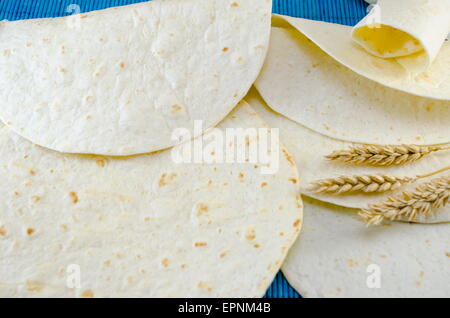 Tortillas fraîches et un bâton de blé sur une nappe bleue Banque D'Images