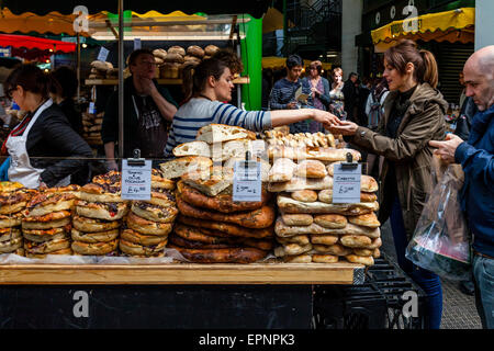 Une femme achète du pain frais à Borough Market, London Bridge, Londres, Angleterre Banque D'Images