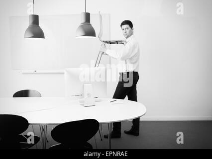 Businessman carrying président en exercice. Image conceptuelle de délocalisation des entreprises, en démarrage ou en changer. Banque D'Images