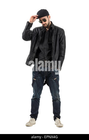 Jeune homme barbu portant casquette, lunettes en blouson de cuir. La longueur du corps complet isolé portrait sur fond blanc. Banque D'Images