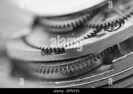 Fond noir et blanc avec des roues dentées en métal une horlogerie. Photo conceptuelle pour la réussite de votre modèle d'affaires. Macro. Banque D'Images