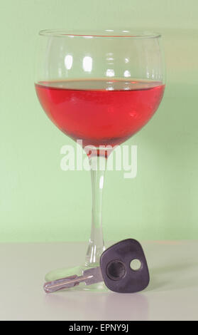 Vin rouge dans un verre avec des clés de voiture avec un fond vert - une référence pour les questions de l'alcool au volant Banque D'Images