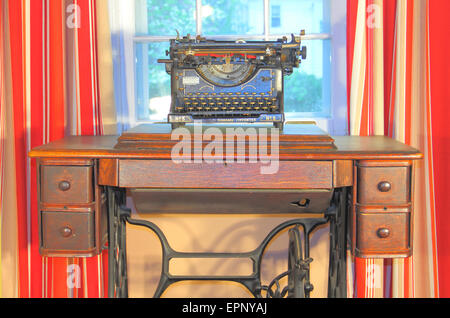Une machine à écrire vintage sur un bureau avec des rideaux rouges Banque D'Images