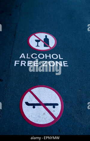 Zone libre de l'alcool et pas de zone skatboarding symboles figurant sur le tarmac à Nelson en Nouvelle-Zélande. Banque D'Images