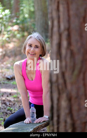 Senior woman resting in forêt après le jogging Banque D'Images