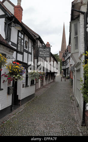 Afficher le long de la rue pavée Church Lane vers le Prince de Galles pub & église située à Ledbury, Herefordshire, Angleterre. Banque D'Images