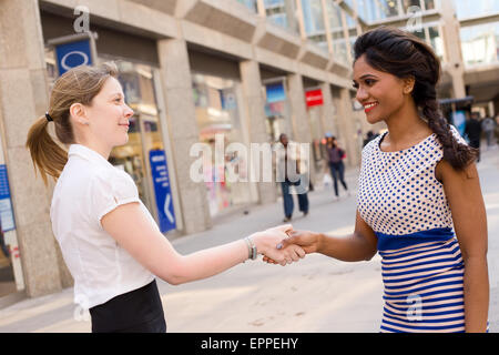 Deux femmes shaking hands Banque D'Images