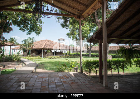 Intérieur de la forteresse Fuerte La Polvora Granada Nicaragua | GRANADA, Nicaragua — Un corridor ombragé et une cour ouverte à l'intérieur de Fuerte la Pólvora offrent une vue sur les toits en tuiles de la forteresse et une tour de guet d'angle s'élevant au-dessus des arbres. Construite en 1748–1749 comme un magasin de poudre à canon fortifié, l'enceinte fonctionne aujourd'hui comme un musée, ses terrains intérieurs étant aménagés autour des structures coloniales subsistantes. Banque D'Images