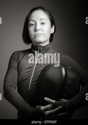 Portrait d'une femme portant des uniformes d'escrime tireur et la tenue d'un masque isolé sur fond gris Banque D'Images