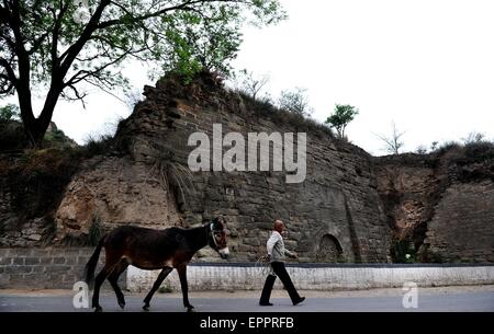 Zichang, Province de Shaanxi en Chine. 20 mai, 2015. Un résident passe devant l'emplacement de l'entrée ouest de la ville de l'opération and Zichang, comté du nord-ouest de la Chine, dans la province de Shaanxi, du 20 mai 2015. Les 1 600 ans, l'opération and Town a la montagne Zhongshan bien conservé des grottes et d'autres architectures de l'antiquité. (Xinhua/Tao Ming) (WF) © Tao Ming/Xinhua/Alamy Live News Banque D'Images