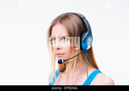 Jeune femme en colère de l'opérateur adjoint dans le casque isolé sur un fond blanc. À l'écart Banque D'Images