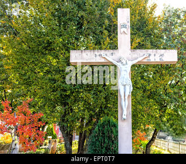 La grande croix blanche en bois avec Jésus Christ crucifié statue à la montagne de l'apparition de Medjugorje parmi les arbres verts et les mauvaises herbes Banque D'Images