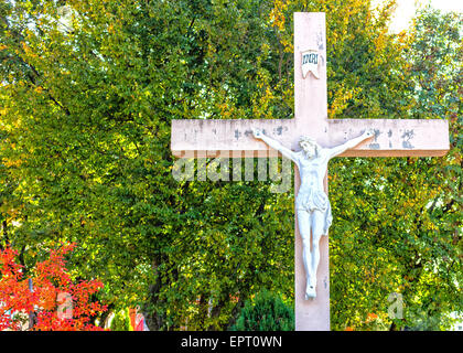 La grande croix blanche en bois avec Jésus Christ crucifié statue à la montagne de l'apparition de Medjugorje parmi les arbres verts et les mauvaises herbes Banque D'Images