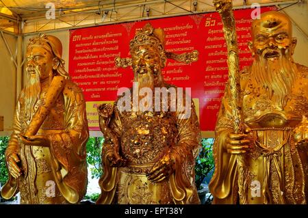 Bangkok, Thaïlande : Trois statues dorées de moines couverte de taches de la feuille d'or appliquée au Wat Hua Lamphong Banque D'Images