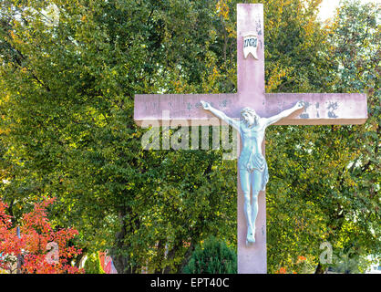 La grande croix blanche en bois avec Jésus Christ crucifié statue à la montagne de l'apparition de Medjugorje parmi les arbres verts et les mauvaises herbes Banque D'Images