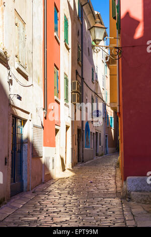 Rue ensoleillée à Rovinj, Croatie avec des maisons de style vénitien, ornate street lamp et shinney cobble stones Banque D'Images