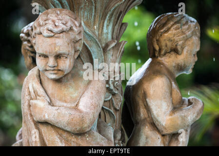 Parque Central Fontaine sculpture Grenade Nicaragua // GRANADA, Nicaragua — Une fontaine décorative avec des sculptures de garçons en togas romains se dresse sur un piédestal dans le centre de Parque Central, la place principale et le cœur historique de Grenade. La place est le centre social et culturel de la ville coloniale, fondée en 1524 et l'une des plus anciennes implantations européennes des Amériques. Le Parque Central est entouré d'une architecture coloniale espagnole colorée, dont la cathédrale jaune caractéristique de Grenade. La plaza reste un lieu de rassemblement populaire pour les habitants et les tou Banque D'Images