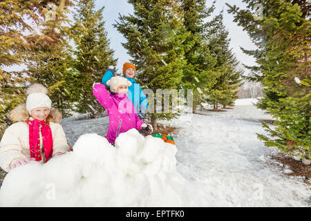 Filles et garçon jouant du jeu de combat de boules de neige Banque D'Images