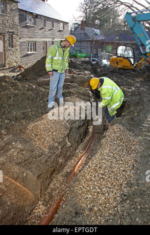 Les travailleurs de la construction d'installer les tuyaux de drainage souterrain en plastique sur un petit développement de l'habitat rural dans le Dorset, UK Banque D'Images