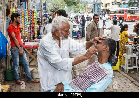 Mumbai Inde,Dharavi,Senapati Bapat Marg,route,homme hommes,barber,rasage,client,trottoir,rue,rasoir à lame unique,travail,India150228023 Banque D'Images