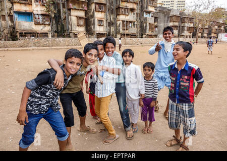 Mumbai Inde,Dharavi,Shahu Nagar Road,bidonville,terrain de terre,terrain de cricket,garçon garçons enfants enfants amis,jouer,bat,India150228034 Banque D'Images