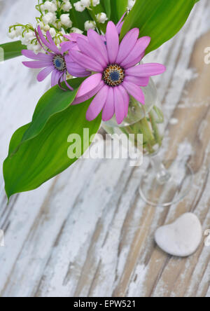 Bouquet de fleurs de printemps sur une planche en bois avec un petit cœur Banque D'Images