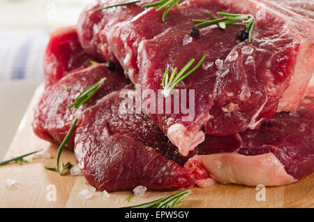 Le boeuf cru t-bone steak sur une planche à découper. Banque D'Images