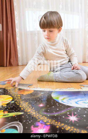 Kid la résolution d'un casse-tête de plancher à la maison Banque D'Images