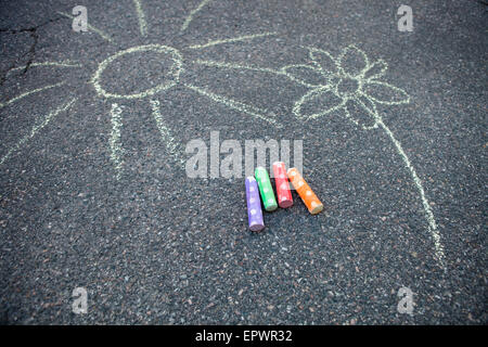 Soleil et fleur appelée sur le sol avec de la craie de rue colorés Banque D'Images