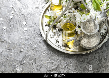 Verres à thé et pot. La vaisselle d'argent oriental. Décoration fleurs de printemps Banque D'Images