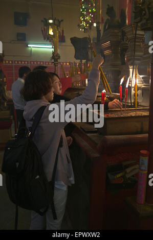 dh Man Mo Temple SHEUNG WAN HONG KONG la femme chinoise joss bâtons temple priant la chine toaïste joss bâton gens Banque D'Images