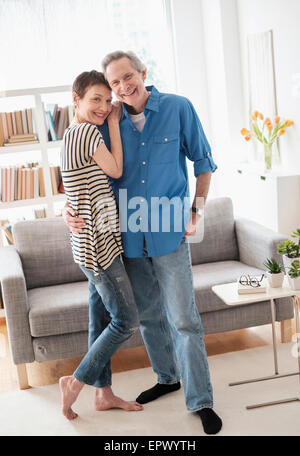 Senior couple embracing in living room Banque D'Images