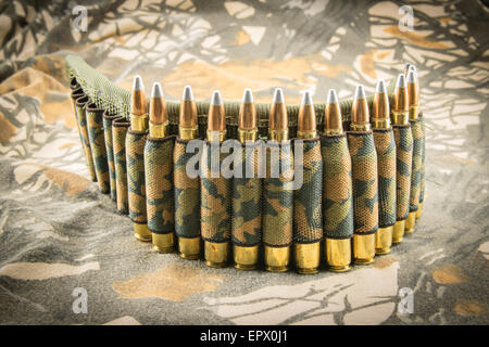 Munitions pour fusil ceinture camouflage sur fond de camouflage Banque D'Images