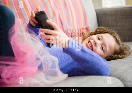 Girl (10-11) wearing tutu playing video game Banque D'Images