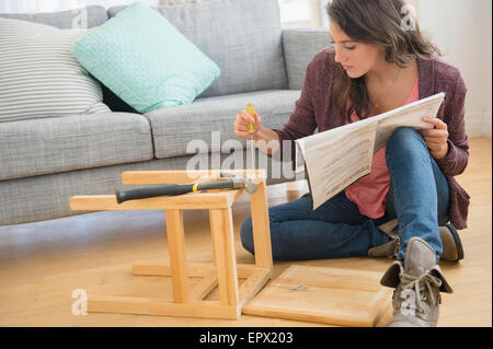 Woman putting ensemble tabouret Banque D'Images